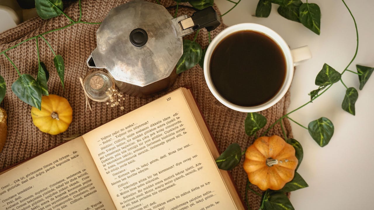 Ariel View of Open Book on Table with Coffee Cup and French Press